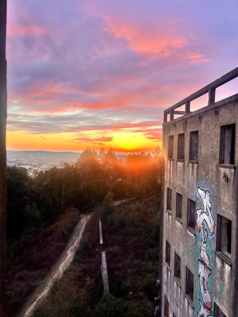 O Sanatório de Valongo é um lugar onde a história, o mistério e a beleza se cruzam. Antigo espaço de tratamento da tuberculose, hoje abandonado, tornou-se um ponto de visita marcado pela sua imponência, pelas ruínas cobertas de grafitis e pela vista deslumbrante sobre a Serra de Santa Justa. Entre lendas e silêncio, o edifício convida à contemplação e à memória, lembrando que mesmo os lugares marcados pela dor podem transformar-se em espaços de encanto, inspiração e reflexão.